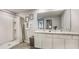 Modern bathroom with double sinks, a shower, and gray tile floor at 30908 Wild Juniper Ct, Brooksville, FL 34602