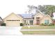 House exterior featuring solar panels, two-car garage, and landscaped lawn at 812 Walsingham Way, Valrico, FL 33594