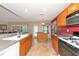 Modern kitchen with wood cabinets, granite countertops, and breakfast bar at 11847 Dunster Ln, Parrish, FL 34219
