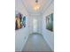 Bright entryway with white walls, tiled floors, transom window and colorful art leading into the home at 1280 Windy Bay Shl, Tarpon Springs, FL 34689