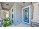 Inviting front porch with green chairs and a blue door at 1280 Windy Bay Shl, Tarpon Springs, FL 34689