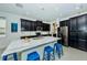 Modern kitchen with dark cabinets, marble countertops, and island seating at 1280 Windy Bay Shl, Tarpon Springs, FL 34689