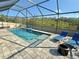 Inviting screened pool featuring in-pool lounging and an adjacent paver patio with space for seating at 1280 Windy Bay Shl, Tarpon Springs, FL 34689