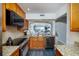 Kitchen with granite counters, stainless steel appliances, wood cabinets, and open to the living area at 6372 Palma Del Mar S Blvd # Apt 307, St Petersburg, FL 33715