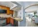Open-concept kitchen view to living room with granite counters, stainless steel appliances, and wood cabinets at 6372 Palma Del Mar S Blvd # Apt 307, St Petersburg, FL 33715