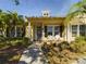 Front view of a yellow house with a porch and white chairs at 5516 Luminar Pointe Ln, Apollo Beach, FL 33572