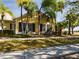 Charming yellow house with palm trees and a landscaped yard at 5516 Luminar Pointe Ln, Apollo Beach, FL 33572