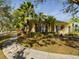 Yellow house with palm trees and a curved walkway at 5516 Luminar Pointe Ln, Apollo Beach, FL 33572