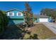 Teal house with white shutters and a spacious yard at 1008 Highgrove Ct, Valrico, FL 33596