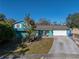 Teal home with a white garage door and arched entryway at 1008 Highgrove Ct, Valrico, FL 33596