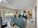 Cozy living room with teal sofa and view of kitchen and backyard at 1008 Highgrove Ct, Valrico, FL 33596