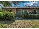 Front view of a brick ranch house with a green door and landscaped yard at 1813 Laurel Oak Dr, Valrico, FL 33596