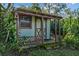 Exterior view of a wooden storage shed with a covered porch at 1813 Laurel Oak Dr, Valrico, FL 33596