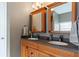 Bathroom features dual sinks, granite counters, wood cabinets, and framed mirrors, offering a clean and bright space at 5808 Falconcreek Pl, Lithia, FL 33547