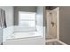 Bright bathroom featuring soaking tub with tile surround and walk-in shower with glass door at 5808 Falconcreek Pl, Lithia, FL 33547
