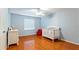 Cozy bedroom features hardwood floors, neutral paint, and a crib, perfect for a Bedroom or young room at 5808 Falconcreek Pl, Lithia, FL 33547