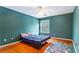 Bedroom with hardwood floors, ceiling fan, and teal colored walls at 5808 Falconcreek Pl, Lithia, FL 33547