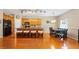 Open kitchen with island seating, wood floors, black appliances, and a dining table at 5808 Falconcreek Pl, Lithia, FL 33547