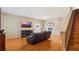 Cozy living room featuring hardwood floors, staircase, and a large tv at 5808 Falconcreek Pl, Lithia, FL 33547