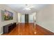 Spacious living room with hardwood floors, fan, television, and windows providing an abundance of natural light at 5808 Falconcreek Pl, Lithia, FL 33547