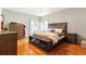 Comfortable main bedroom showcases hardwood floors, neutral paint, windows for natural light, and stylish furnishings at 5808 Falconcreek Pl, Lithia, FL 33547