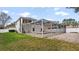 View of in-ground pool with screened enclosure, travertine pavers, and backyard grass at 5808 Falconcreek Pl, Lithia, FL 33547
