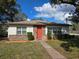 Charming single-story home featuring a red front door, stone accents, and well-manicured landscaping at 702 W Cherry St, Plant City, FL 33563