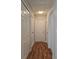 Hallway with multiple white doors, closets, and wood-look flooring at 702 W Cherry St, Plant City, FL 33563