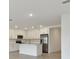 Modern kitchen with white cabinets, quartz countertops, and stainless steel appliances at 5213 Patano Loop, Palmetto, FL 34221