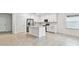 Open concept kitchen features white cabinets, stainless steel appliances & breakfast bar at 5217 Patano Loop, Palmetto, FL 34221