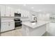 Modern kitchen features white cabinets, stainless steel appliances & a large quartz island at 5217 Patano Loop, Palmetto, FL 34221