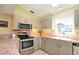 Well-lit kitchen with granite countertops, stainless steel appliances, and tiled backsplash at 1206 Laurel Pines Cir, Nokomis, FL 34275