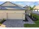 Tan house with gray roof, two-car garage, and paved driveway at 18053 Cherished Loop, Bradenton, FL 34211