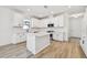 Modern kitchen with white cabinets, island, and hardwood floors at 18053 Cherished Loop, Bradenton, FL 34211