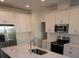 White shaker cabinets, stainless steel appliances, and a large quartz island at 310 Via Anina Dr, Sarasota, FL 34243