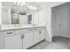 Double vanity bathroom with white cabinets and grey tile floors at 5406 Tripoli Dr, Palmetto, FL 34221