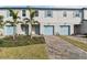 Three-unit townhome building with light blue garage doors and landscaping at 5414 Tripoli Dr, Palmetto, FL 34221