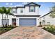 Two-story townhome with a blue garage door and a brick paver driveway at 5429 Tripoli Dr, Palmetto, FL 34221