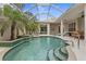 Relaxing pool and spa with palm trees and a covered patio at 750 Pond Lily Way, Venice, FL 34293