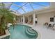 Inviting pool area with covered patio, lush landscaping, and comfortable seating at 750 Pond Lily Way, Venice, FL 34293