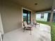 Covered patio with two chairs and access to the backyard at 11854 Thicket Wood Dr, Riverview, FL 33579