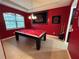 Game room with pool table and red walls at 11854 Thicket Wood Dr, Riverview, FL 33579