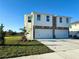 Two-story house with a two-car garage, stone accents, and a neatly landscaped lawn at 13719 Emerald Fields Dr, Hudson, FL 34667