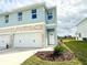 Two-story light blue townhome with a two-car garage and landscaping at 13992 Emerald Fields Dr, Hudson, FL 34667