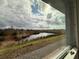 View of a pond from a window, showcasing serene natural beauty at 13998 Emerald Fields Dr, Hudson, FL 34667