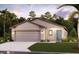 Two-car garage, light-colored exterior, landscaping, and a teal front door at 16881 Fiesta Dr, Port Charlotte, FL 33953