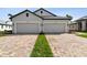 Two-car garage, light gray exterior, and a nicely landscaped front yard at 18040 Cherished Loop, Bradenton, FL 34211