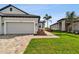 Tan two-car garage with landscaping, and a walkway at 18040 Cherished Loop, Bradenton, FL 34211