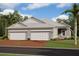 Two-car garage, gray exterior, and brick driveway at 18071 Cherished Loop, Bradenton, FL 34211