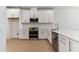 Modern kitchen with white cabinets, quartz countertops, and stainless steel appliances at 18178 Cherished Loop, Bradenton, FL 34211